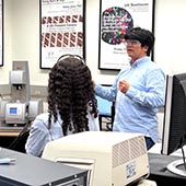 Hiroaki Sai, the Acting Director of the ANTEC core facility, gives a laboratory tour to high school students